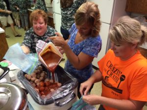 Our Savior United Methodist Church members Rita Cue, Holly Witham and Kim Fryman load up another tub of hamballs.