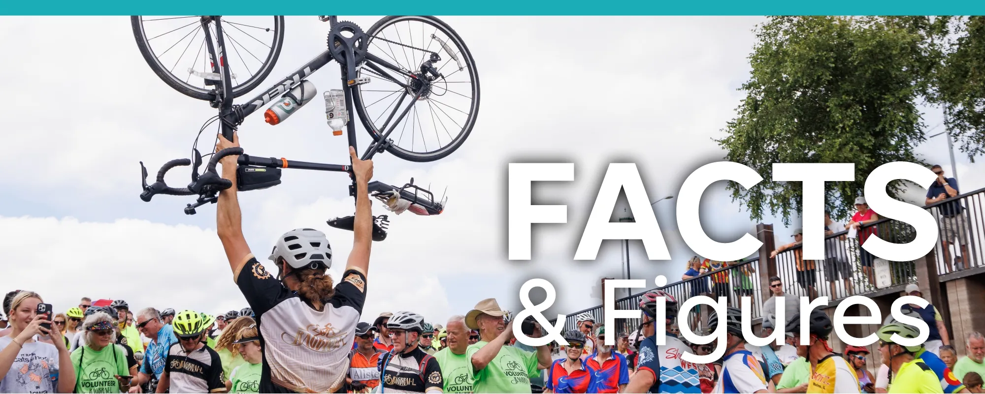 man raising bike with crowd